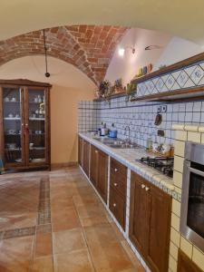 a large kitchen with a brick wall at Casa Collarano in San Demetrio neʼ Vestini