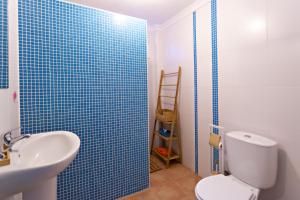 baño con aseo y pared de azulejos azules en Conchas da Fabrica, en Vila Nova de Cacela