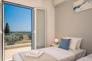 sypialnia z łóżkiem i dużym szklanym oknem w obiekcie Villa Elaionas 2 in Svoronata! w mieście Svoronata