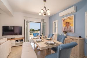 jadalnia ze stołem i niebieskimi krzesłami w obiekcie Villa Elaionas 2 in Svoronata! w mieście Svoronata