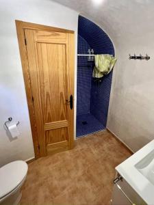 een badkamer met een toilet en een douche met een deur bij Casa rural Cueva Los Aviones, río Chícamo 