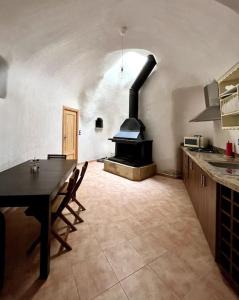 een keuken met een tafel en een fornuis. bij Casa rural Cueva Los Aviones, río Chícamo 
