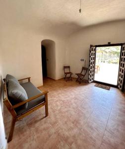 een woonkamer met een bank en een groot raam bij Casa rural Cueva Los Aviones, río Chícamo 