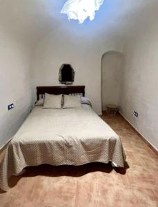 een slaapkamer met een bed en een kroonluchter bij Casa rural Cueva Los Aviones, río Chícamo 
