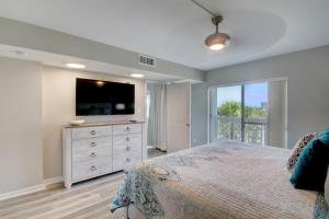 Dormitorio con cama y tocador con TV en El Matador 430 - Third floor unit, en Fort Walton Beach 22 fotos más