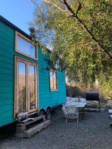 a blue tiny house with a table in front of it at Hermosa Tiny House con Vista al Chapelco in San Martín de los Andes