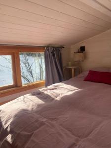 um quarto com uma cama e uma janela em Hermosa Tiny House con Vista al Chapelco em San Martín de los Andes