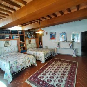 a room with two beds and a rug at House In A Medieval Hamlet in Cerreto Guidi