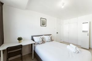 ein kleines Schlafzimmer mit einem Bett und einem Schreibtisch in der Unterkunft Stratford Cosy rooms - 17 in London