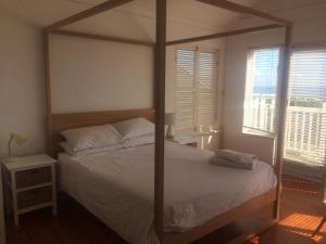 ein Schlafzimmer mit einem großen Bett mit einem Holzrahmen in der Unterkunft Rustic Beach House 300 Steps from the Ocean in Kapstadt
