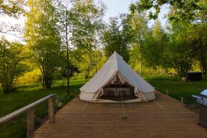 a tent on a wooden boardwalk in a park at Glamping Žvaigždžių slėnyje 