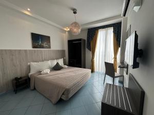 a hotel room with a bed and a television at Hotel Centrale FRONTE MARE in Milano Marittima +49 photos