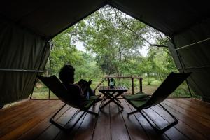 a person sitting in a hammock in a tent at Kulu Safaris - All Inclusive in Yala