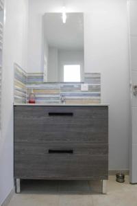 uma casa de banho com um lavatório e um espelho em Maisonnette neuve Monbazillac em Monbazillac