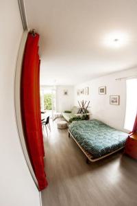 a living room with a bed and a mirror at Studio le Flamboyant in Cholet