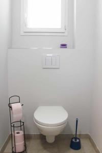 a white bathroom with a toilet and a window at Maisonnette neuve Monbazillac in Monbazillac