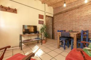 a living room with a table and a television at Pai Pay Calido y Confortable Bungalow in San Carlos de Bariloche