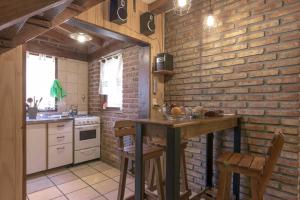 a kitchen with a table and a brick wall at Pai Pay Calido y Confortable Bungalow in San Carlos de Bariloche