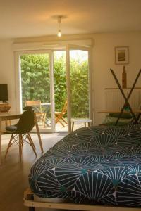 Schlafzimmer mit einem Bett, einem Schreibtisch und einem Fenster in der Unterkunft Studio le Flamboyant in Cholet
