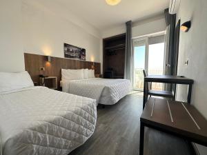 um quarto de hotel com duas camas e uma janela em Hotel Centrale em Milano Marittima