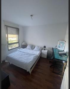 a bedroom with a bed and a desk and a computer at Chambre chez l’habitant à Strasbourg in Strasbourg