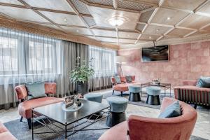 a lobby with pink walls and chairs and a table at Hotel Tyrolerhof in Sölden