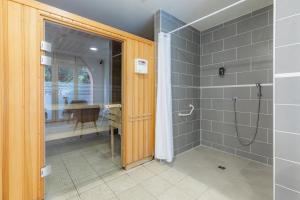 uma casa de banho com um chuveiro e uma porta de vidro em Appart'City Classic Toulouse Colomiers em Colomiers