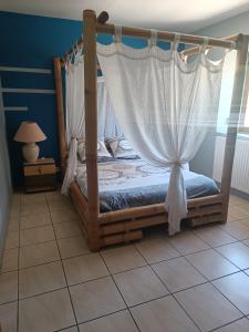 ein Schlafzimmer mit einem Himmelbett und einem Vorhang in der Unterkunft Taborda familly 