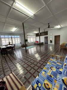 Cette grande chambre comprend une table et des chaises. dans l'établissement Warisan Homestay A, à Mersing