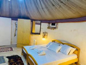 ein Schlafzimmer mit einem großen Bett mit weißer Bettwäsche und Kissen in der Unterkunft Pink city cottage in Wadi Musa