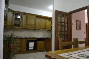 una cocina con armarios de madera y una mesa en una habitación en B&B La Terrazza sul Parco, en Sulmona