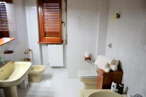 Baño blanco con aseo y lavamanos en B&B La Terrazza sul Parco, en Sulmona