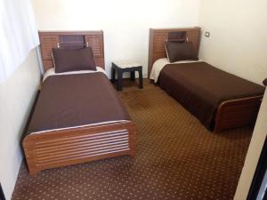 two beds in a small room withskirts at شقة سيلا in Irbid