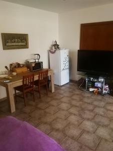 een woonkamer met een televisie en een tafel met stoelen bij Vila Barrandov in Praag