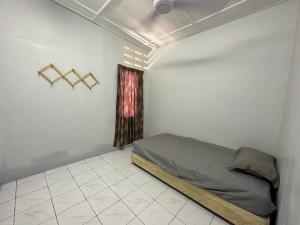 a bedroom with a bed in a room with a window at Warisan Homestay B in Mersing