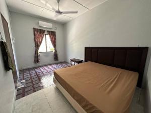 a bedroom with a large bed and a window at Warisan Homestay B in Mersing +3 photos