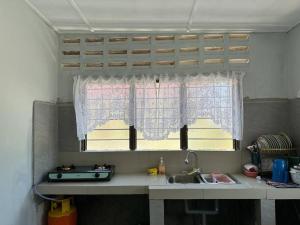 a kitchen with a sink and a window at Warisan Homestay B in Mersing