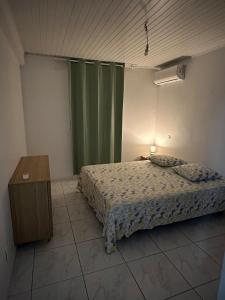 ein Schlafzimmer mit einem Bett und einem grünen Vorhang in der Unterkunft Chez Nouny in Le Marin