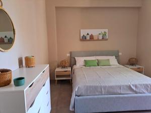 Schlafzimmer mit einem Bett, einer Kommode und einem Spiegel in der Unterkunft elegance b&b in Cariati