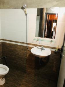 Un baño con lavabo, inodoro y espejo. en Sần's House, en Lào Cai