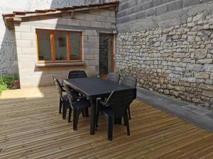 a black table and chairs on a wooden deck at le vieux chêne in Parois