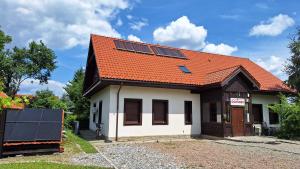 a house with an orange roof with solar panels on it at Eko Dom Eturia in Suchoraba