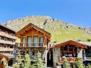 un bâtiment avec une montagne en arrière-plan dans l'établissement Studio Val-d'Isère, 1 pièce, 3 personnes - FR-1-411-200, à Val dʼIsère