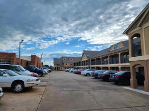 um parque de estacionamento com carros estacionados em frente aos edifícios em Executive inn em Oklahoma City