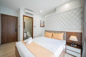 a bedroom with a large bed and a bathroom at Cozrum Homes - Kena House in Ho Chi Minh City