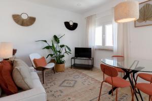 a living room with a white couch and a glass table at FLH Alcântara Comfy Flat with Balcony in Lisbon