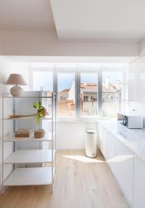 里斯本的住宿－FLH Alcântara Comfy Flat with Balcony，厨房配有白色橱柜和带台灯的桌子