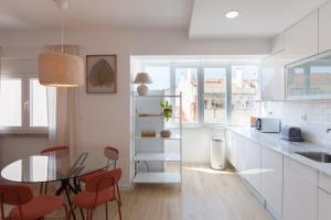 a kitchen with a glass table and red chairs at FLH Alcântara Comfy Flat with Balcony in Lisbon