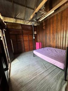 Habitación pequeña con cama y pared de madera. en Warisan Homestay Anjung en Mersing