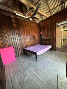 a bedroom with a bed in a wooden room at Warisan Homestay Anjung in Mersing